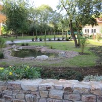 Blick auf einen Garten mit Teich, hier befindet sich der Wohnmobilstellplatz