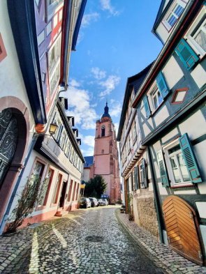 Der Kirchturm von St. Peter und Paul ragt zwischen Fachwerkhäusern in der Altstadt empor.