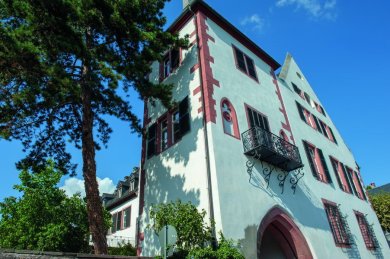 Der Eltzer Hof, ein turmartiges Gebäude mit Balkon,  in dem sich unten das Martinstor befindet.