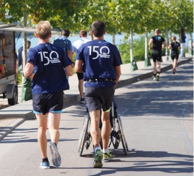 Zwei Läufer von hinten, die entlang des Rheinufers joggen
