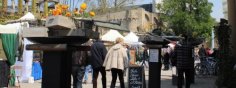 Die Gäste erwarten bunte Stände rund um den Frühling und Live-Musik am romantischen Rheinufer. Menschen laufen an Ständen auf dem Leinpfad entlang, im Hintergrund sieht man die Eltviller Burg.