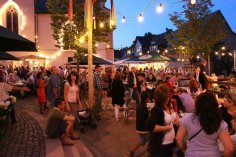 Das Rauenthaler Kirchweihfest findet immer im August statt. Gäste sitzen und stehen zusammen beim Kirchweihfest am Abend.