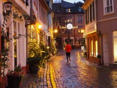 Eltville leuchtet - Weihnachten liegt in der Luft. Die Eltviller Altstadtstraßen sind mit Weihnachtslichtern geschmückt, dazwischen ist ein Jogger unterwegs, den man von hinten sieht.