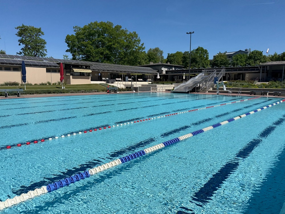 Schwimmerbecken mit Rutsche im HIntergrund
