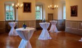 Auch Sektempfänge sind im Burgsaal möglich. Stehtische mit Blumenschmuck und weißen Hussen stehen im Burgsaal.