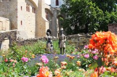 Das Biedermeierpaar am Rheinufer erstrahlt im bunten Rosenbeet. Das bronzene Biedermeierpaar steht im blühenden Rosenbeet vor der Kurfürstlichen Burg.