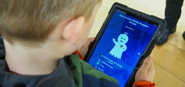 Junge von hinten beim Spielen auf dem Tablet