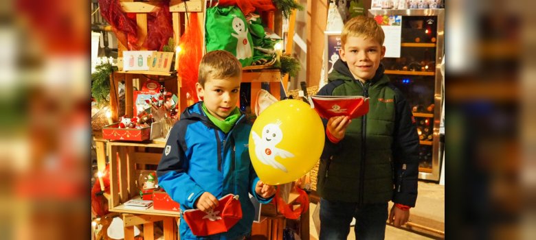 Zwei Jungs mit bunten EMIL-Geschenken im Burgladen