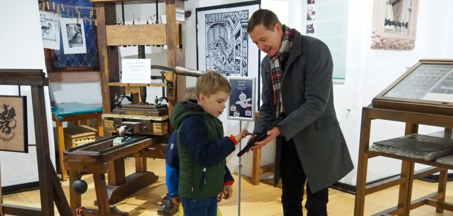 In der Gutenbergausstellung testen zwei Kinder das EMIL-Spiel auf dem Tablet