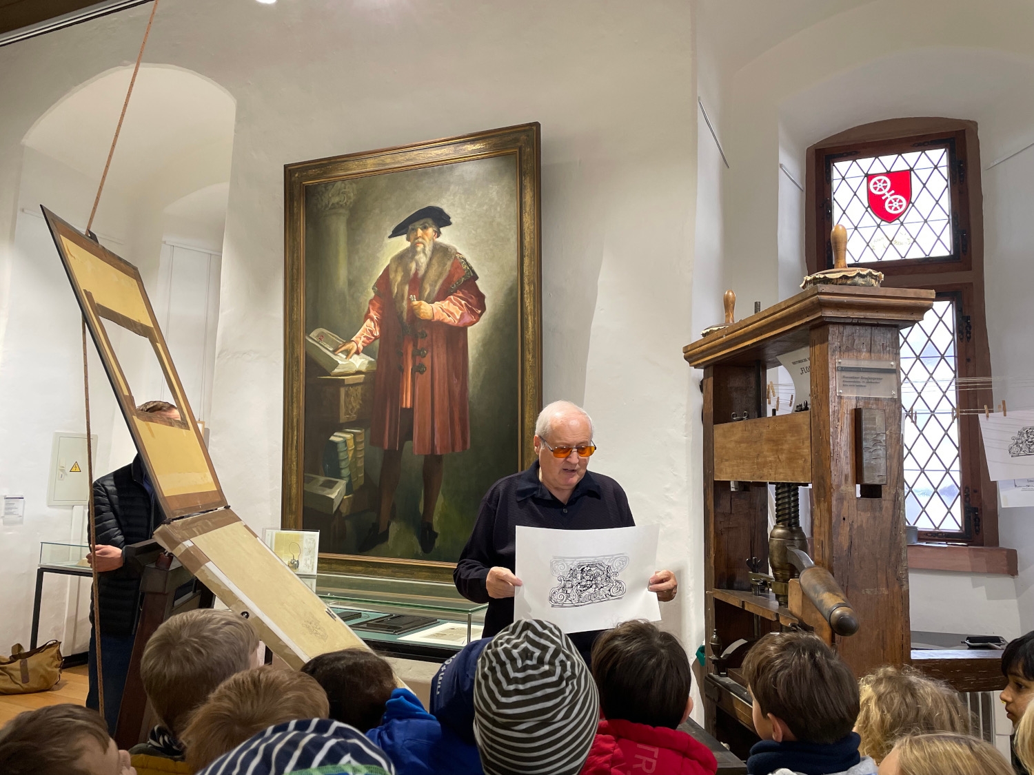 Ein Experte erklärt Kindern das Druckerhandwerk an der historischen Florentiner Presse