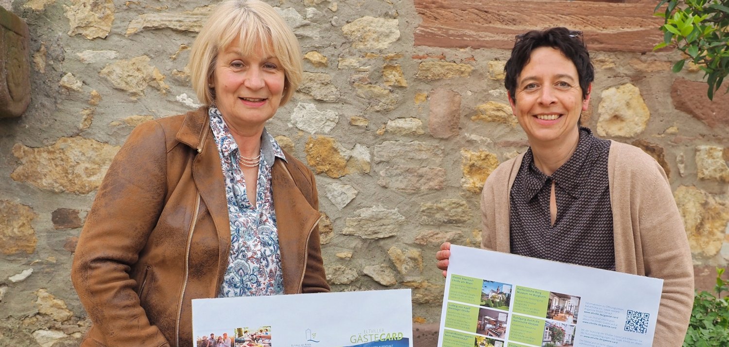 Dezernentin Jutta Scholl-Seibert und Fachbereichsleiterin Susanne Beier (v.l.) halten die ausgedruckte GästeCard im Großformat in den Händen.