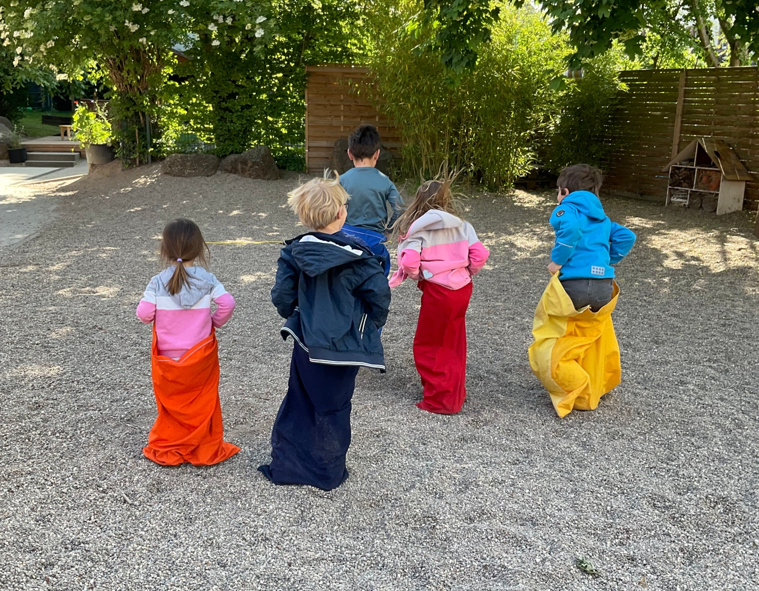 Kinder von hinten fotografiert beim Sackhüpfen