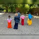 Kinder von hinten fotografiert beim Sackhüpfen