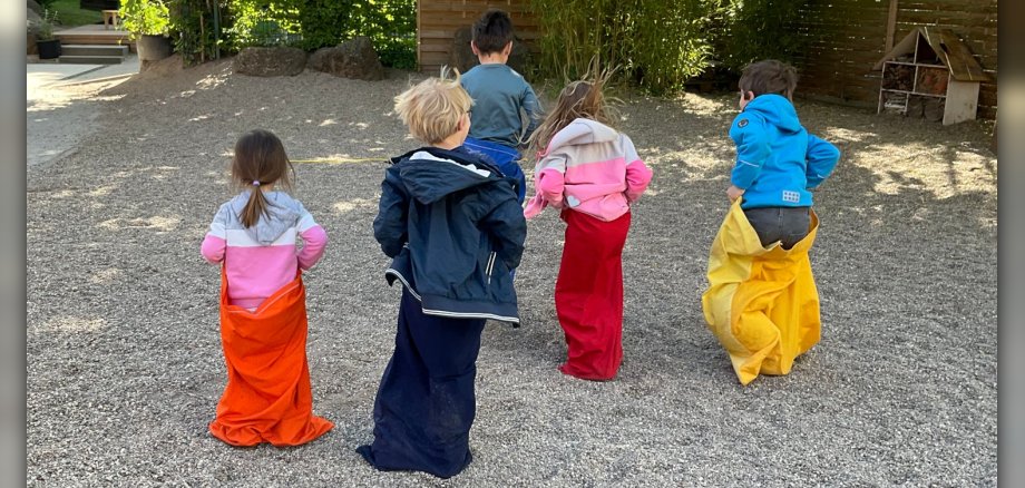 Kinder von hinten fotografiert beim Sackhüpfen