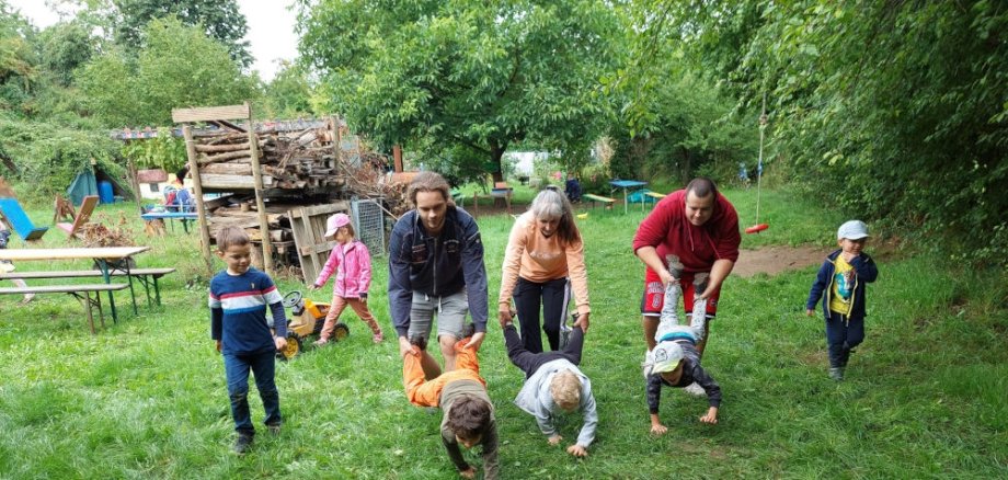 Erzieher und Kinder spielen gemeinsam beim Sportfest