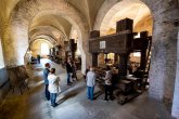 Führung in Kloster Eberbach. Gruppe steht bei einer Führung vor einer Weinkelter in Kloster Eberbach.