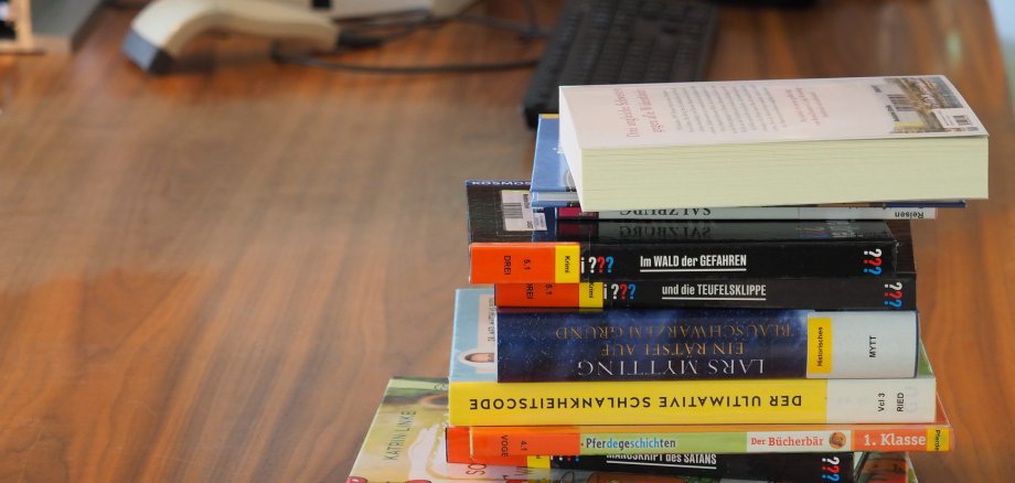 Ein Stapel Bücher liegt auf einem Tisch.