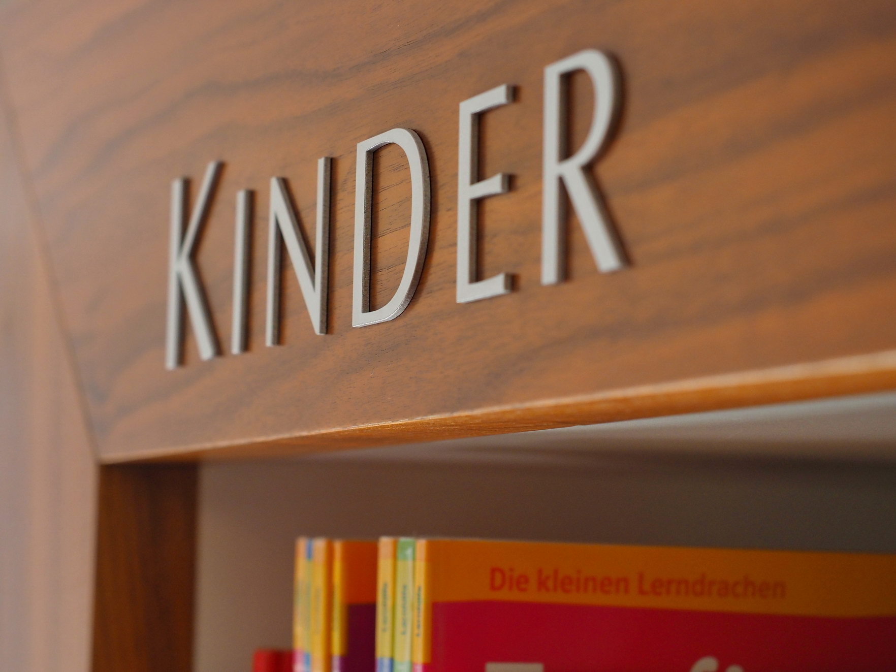 Für Kinder und Jugendliche bietet die Mediathek nicht nur Bücher, sondern auch Tonie-Figuren, Comics und Co an. An einem Bücherregal steht "Kinder".