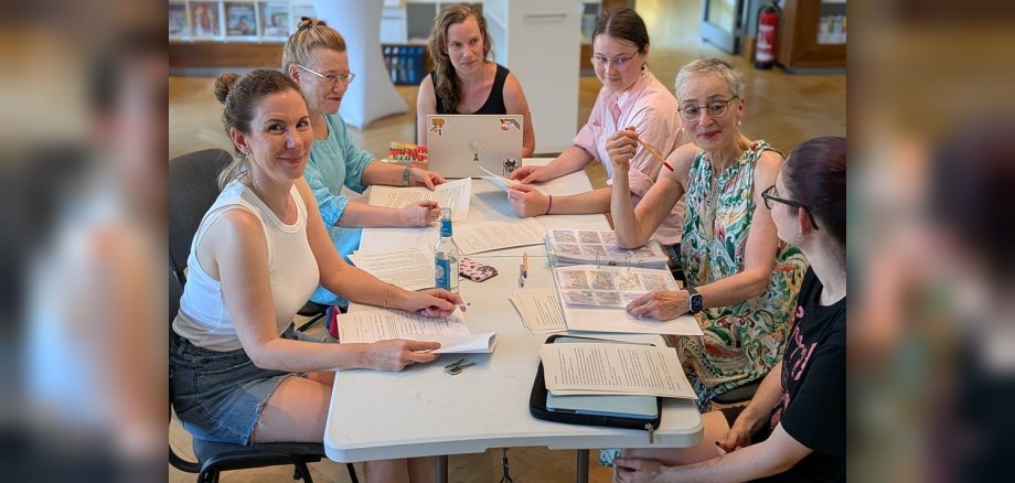 Gruppenfoto Schreiberlinge sitzen an Tisch in der Mediathek