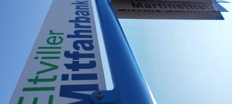 Ein Schild weist auf eine Mitfahrbank in Martinsthal hin.