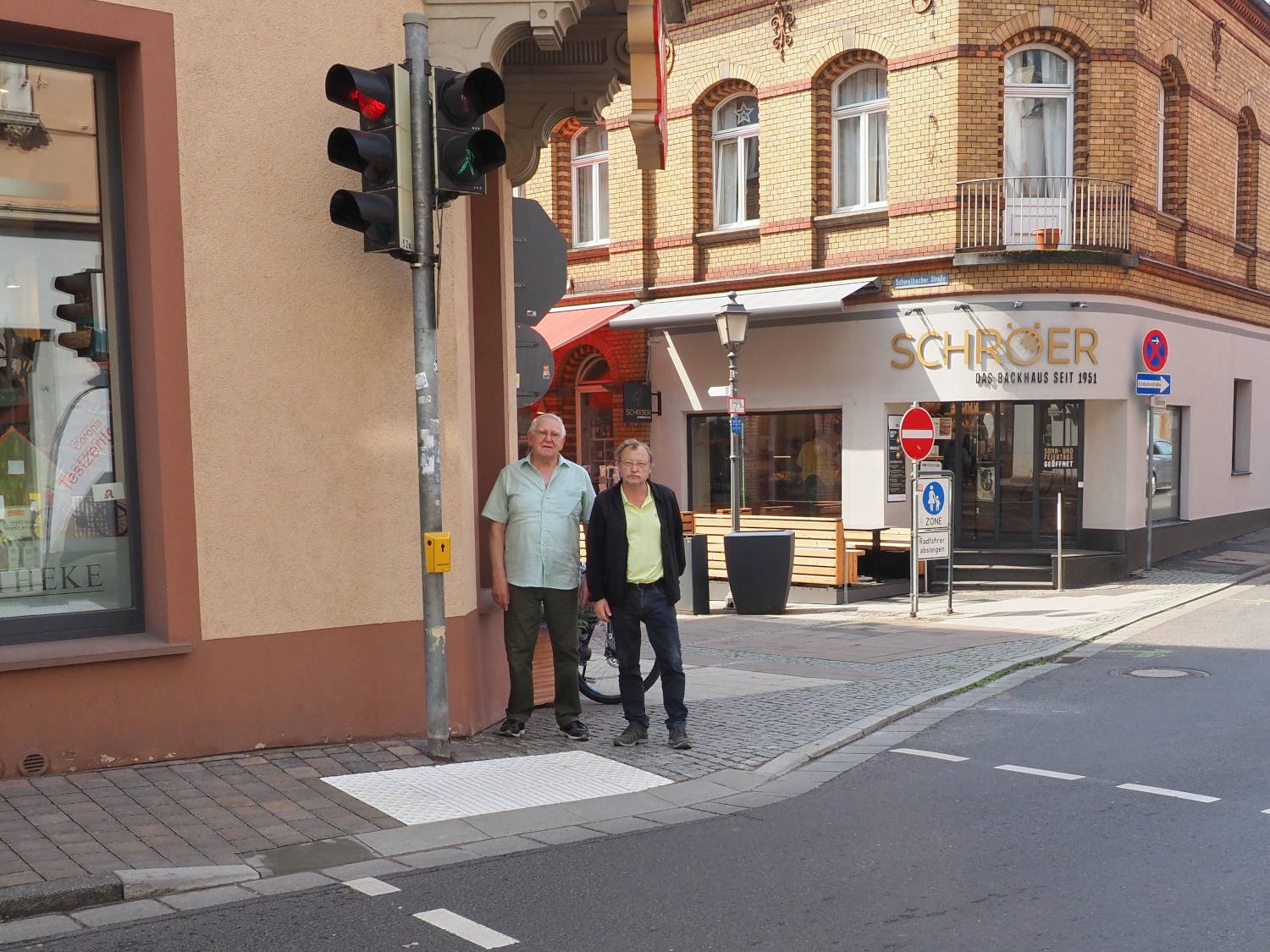 Verkehrsdezernent Hans-Walter Pnischeck (rechts) begutachtet zusammen mit Horst Korte, dem Seniorenbeauftragten der Stadt, den gerade realisierten barrierefreien Ausbau der Kreuzung Schwalbacher Straße mit Kiliansring und Gutenbergstraße.
