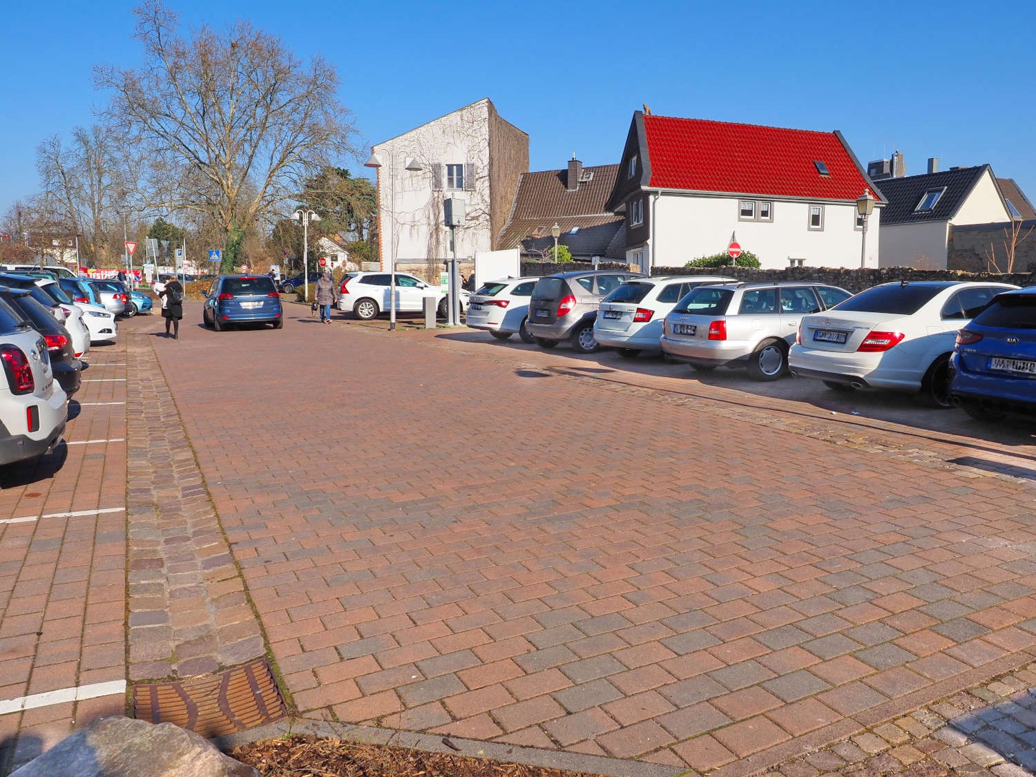 Wo heute noch Autos die Sicht auf die historische Stadtmauer versperren, könnten in Zukunft Eltvillerinnen und Eltviller an heißen Sommertagen im wohltuenden Schatten von Bäumen entspannen. Parkende Autos auf dem Kiliansring-Parkplatz.