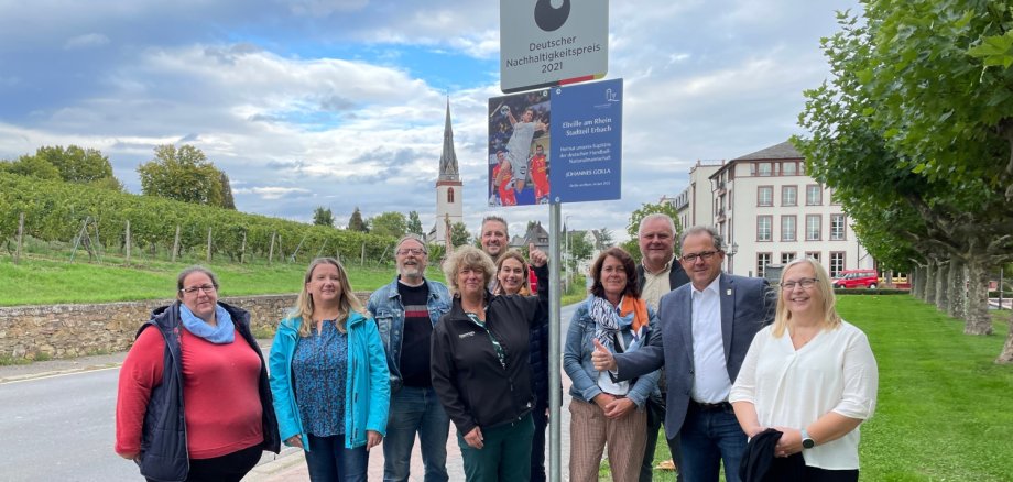 Mitglieder des Ortsbeirates stehen vor dem neu angebrachten Schild für Handballer Johannes Golla am Ortseingang von Erbach.