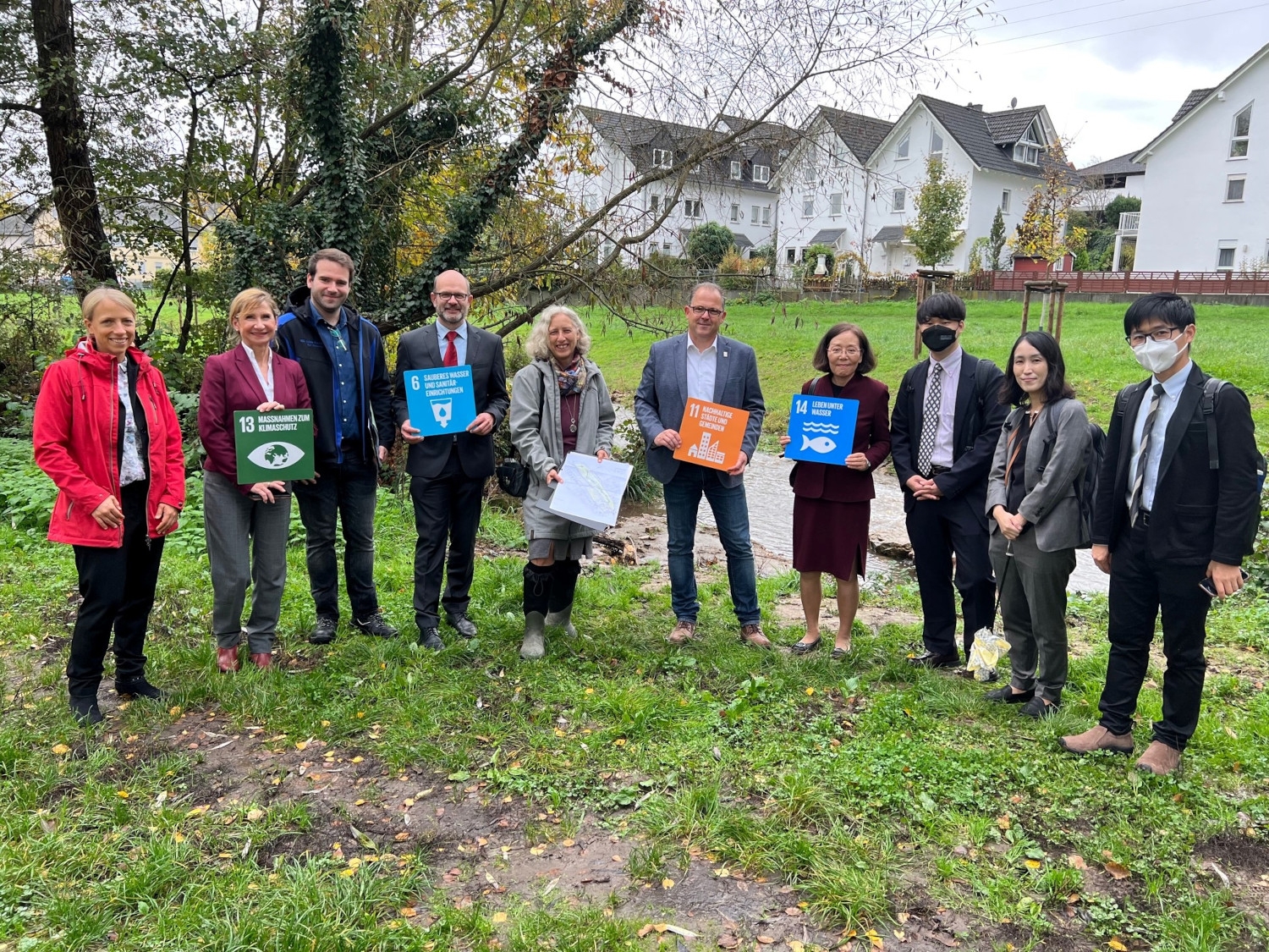 Vertreter der Ministerien, der Stadt Eltville und der Delegation stehen für ein Gruppenfoto vor der renaturierten Walluf.