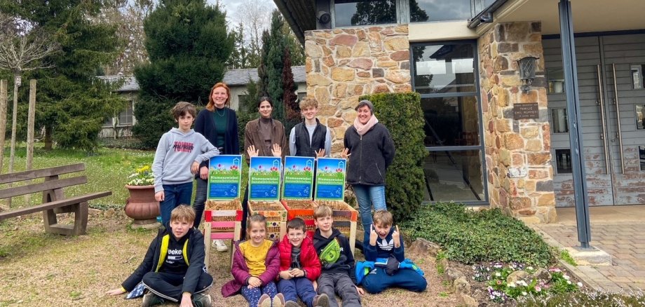 Das Team vom Kindertreff und die Kinder mit den bemalten Kisten vor der Trauerhalle