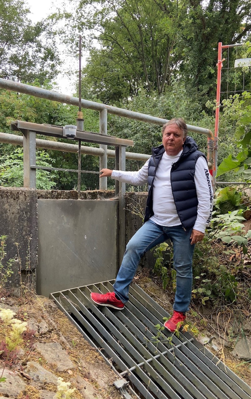 Steffan Seyffardt steht an einem manuellen Schieber am Bach in Hattenheim.