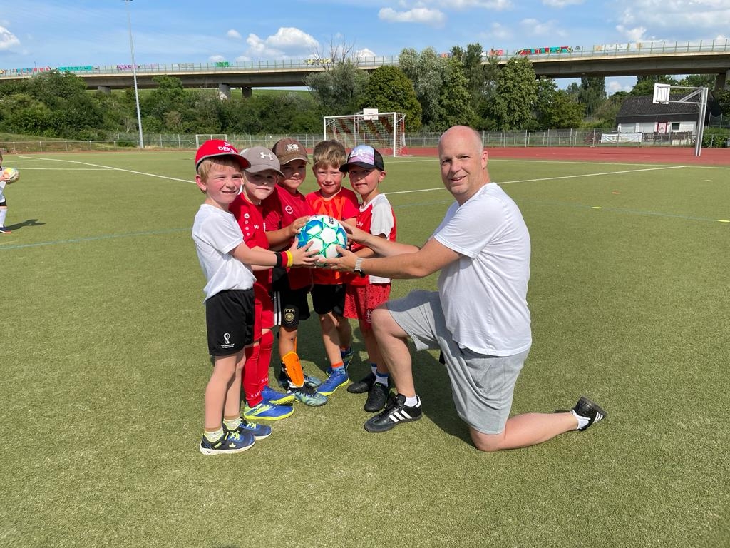 Die Kinder übergeben einen fair gehandelten Fußball an Thomas Gommert