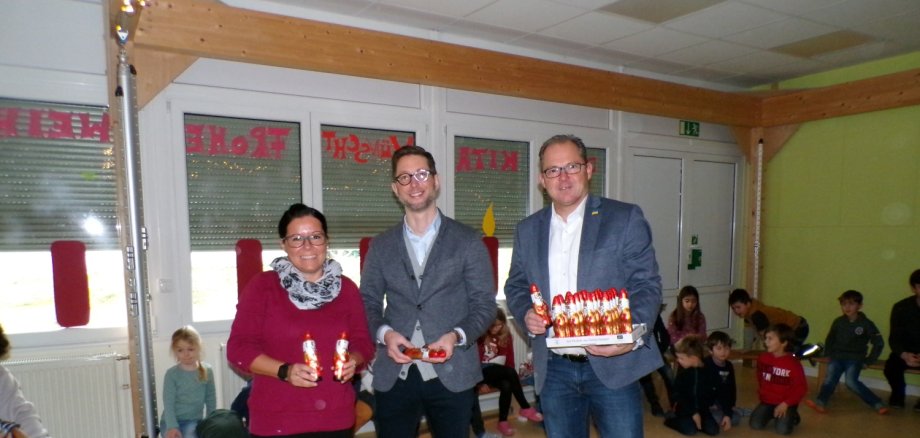 Kitaleitung Daniela Kopp, Amtsleiter für Soziales Thomas Speth und Bürgermeister Patrick Kunkel beim Verteilen der fairen Nikoläuse in Hattenheim.