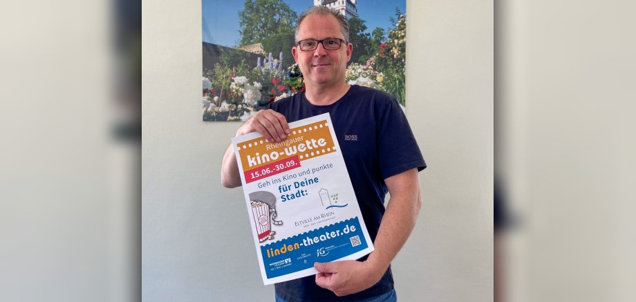 Bürgermeister Patrick Kunkel mit dem Plakat zur Kinowette in der Hand