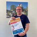 Bürgermeister Patrick Kunkel mit dem Plakat zur Kinowette in der Hand