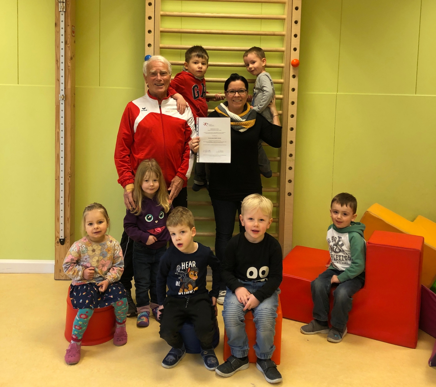 Kitaleiterin Dany Kopp mit Helmut Heisen und Kitakindern bei der Übergabe des Gutscheins in der Kita