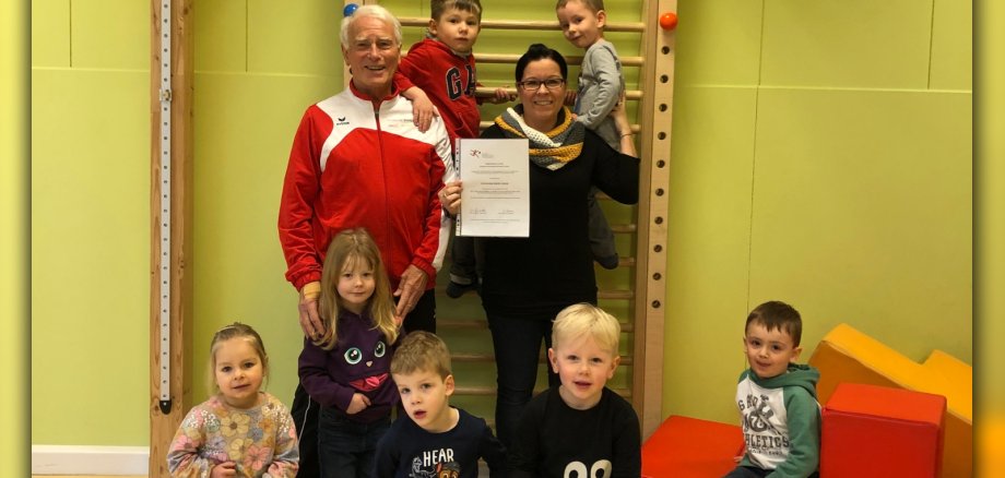 Kitaleiterin Dany Kopp mit Helmut Heisen und Kitakindern bei der Übergabe des Gutscheins in der Kita
