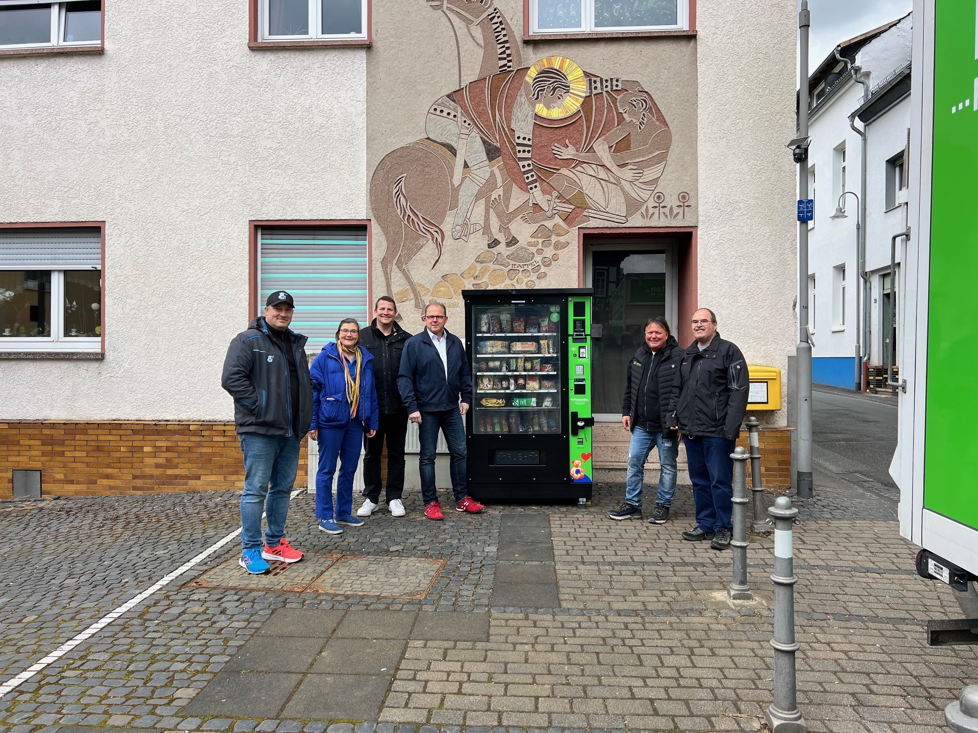 Gruppenfoto vor dem neuen Dorfautomaten