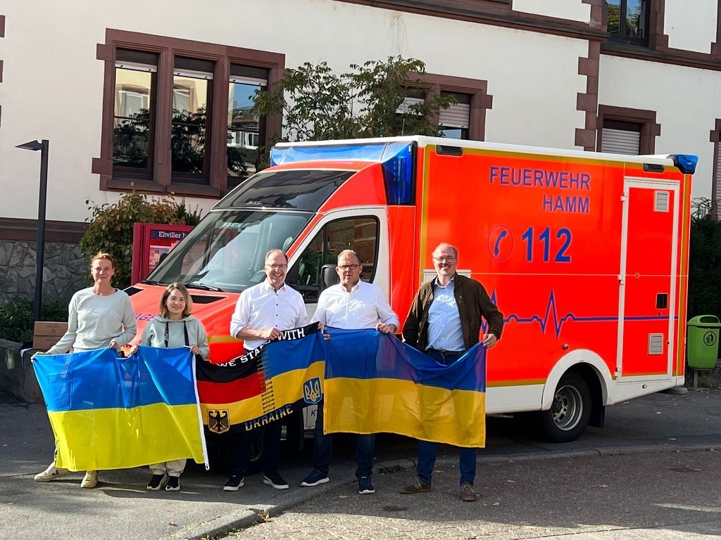 Gruppenfoto vor dem Krankenwagen mit Ukraine-Flagge