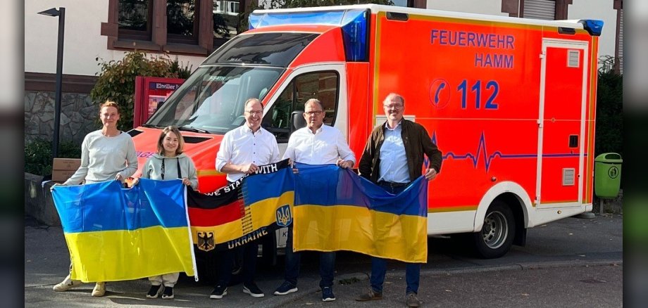 Gruppenfoto vor dem Krankenwagen mit Ukraine-Flagge