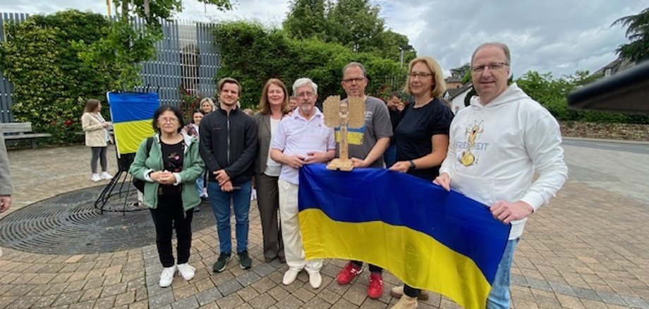 Stadtverordnetenvorsteher Ingo Schon und seine Stellvertreterin Sigrid Hansen sowie Bürgermeister Patrick Kunkel (von rechts) nahmen die Holzfigur der ukrainischen Schutzpatronin aus den Händen des Künstlers Alexander Gorobets entgegen.  
