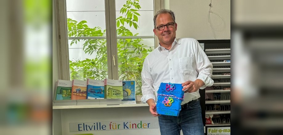 Bürgermeister Kunkel mit dem blauen, gebastelten Briefkasten für Kinderwünsche