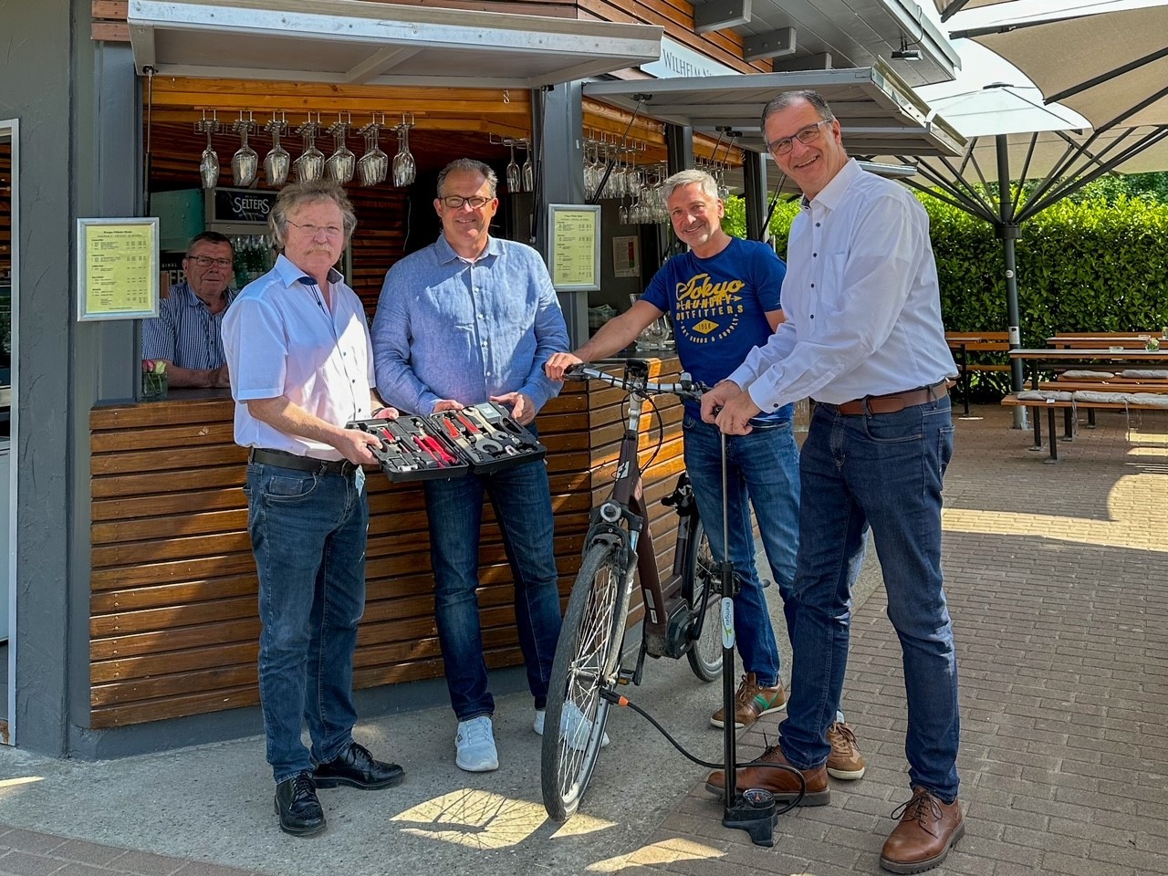 Gruppenfoto mit dem Reparaturset am Weinstand