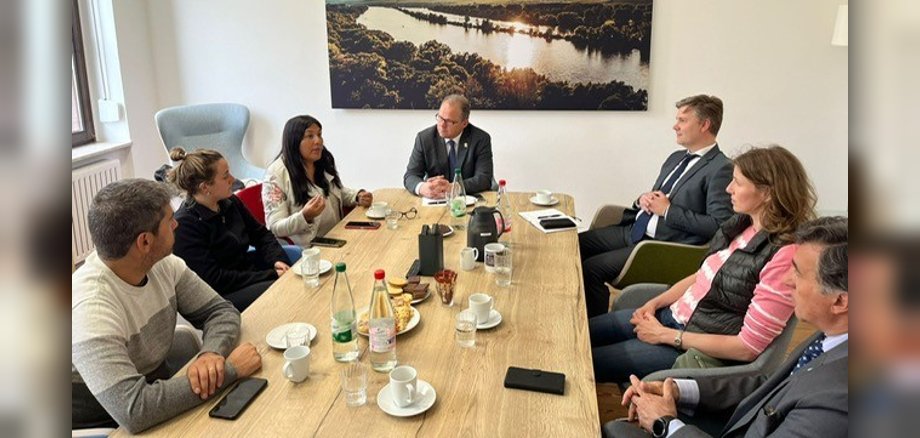 Beteiligte sitzen an einem Besprechungstisch