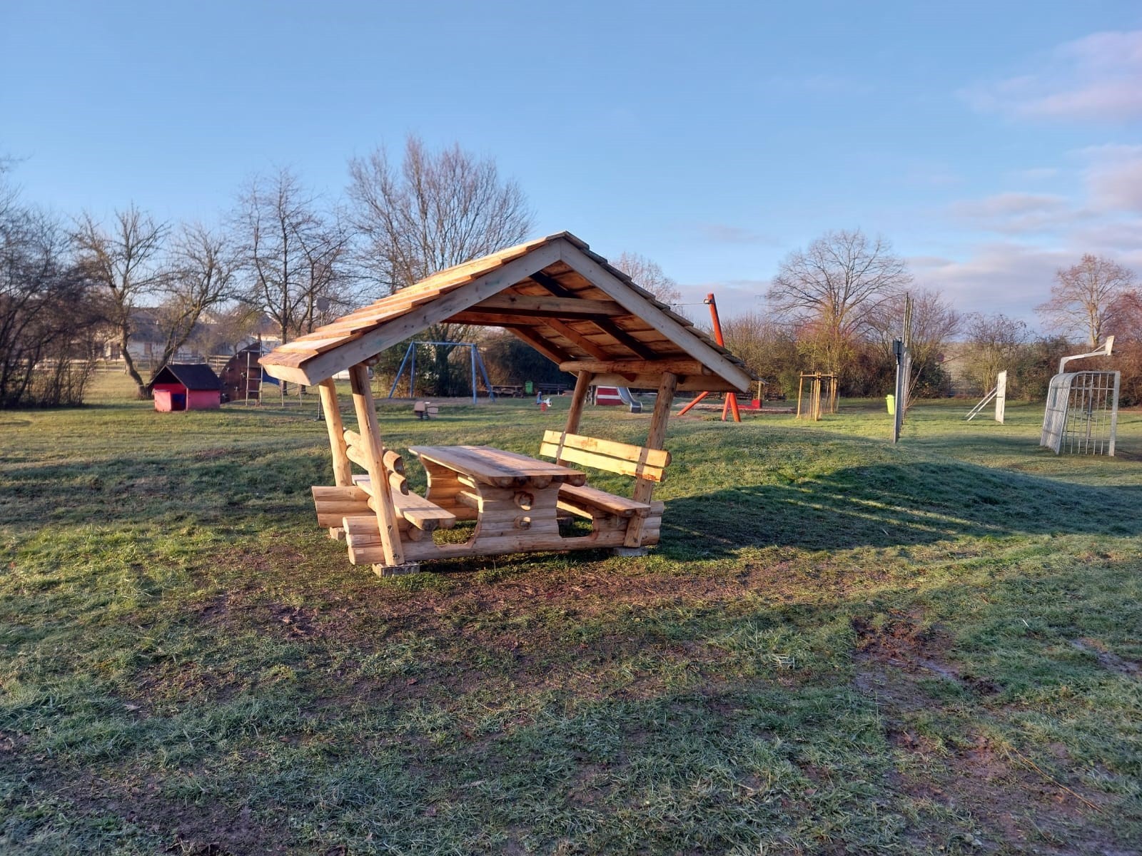Eine überdachte Sitzgelegenheit auf einer Wiese