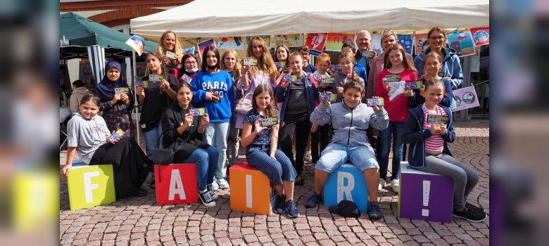 Gruppenfoto: Schülerinnen und Schüler sowie Projekt-Koordinatoren mit der Stadtschokolade in der Hand.