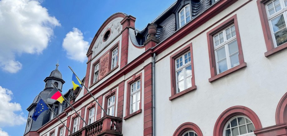 Blick auf das Rathaus mit Balkon. Die Europäische, Deutsche und Ukrainische Flagge sind gehisst.