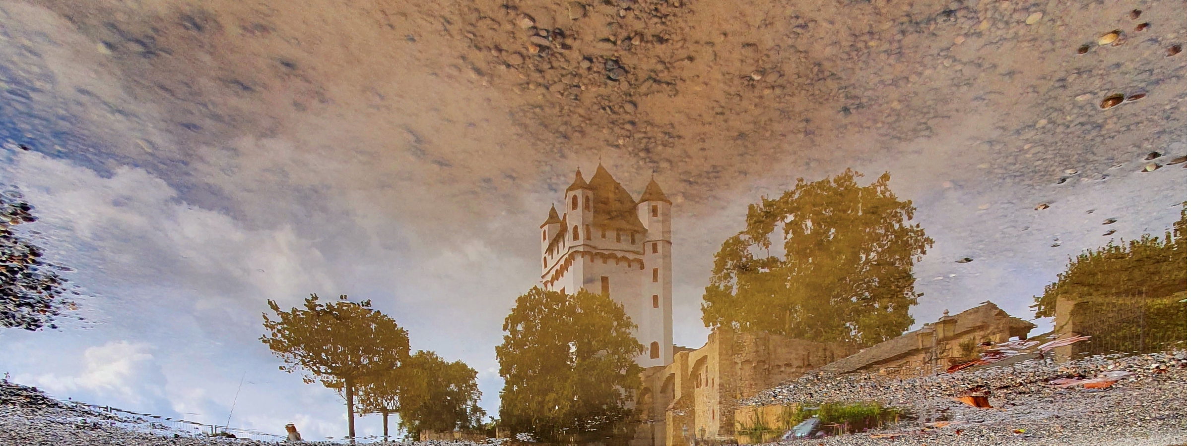 Der Turm der Kurfürstlichen Burg gespiegelt in einer Pfütze.