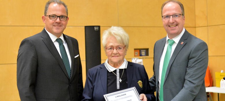 Bürgemeister Kunkel (l.) und Stadtverordnetenvorsteher Schon (r.) übergeben Wilhelmine Schmidt ihre Ehrenbürger-Urkunde.