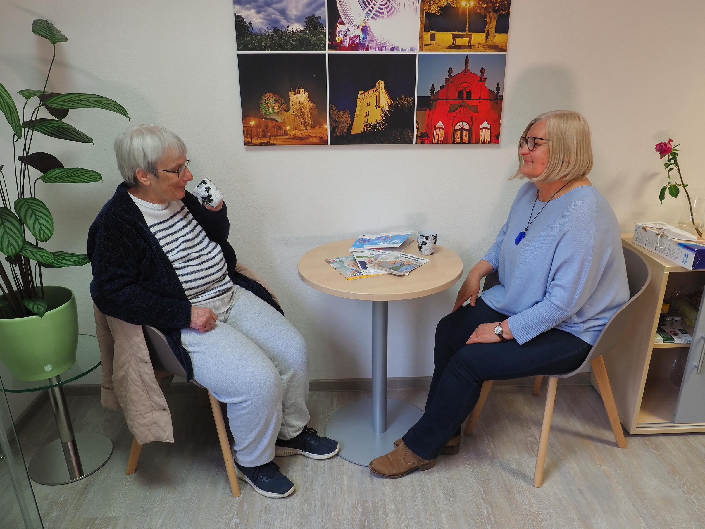 Die Gemeindepflegerin Anna Böttger kümmert sich um alle älteren Eltvillerinnen und Eltviller. Die Gemeindepflegerin Anna Böttger spricht mit einer Seniorin, beide sitzen an einem Tisch.