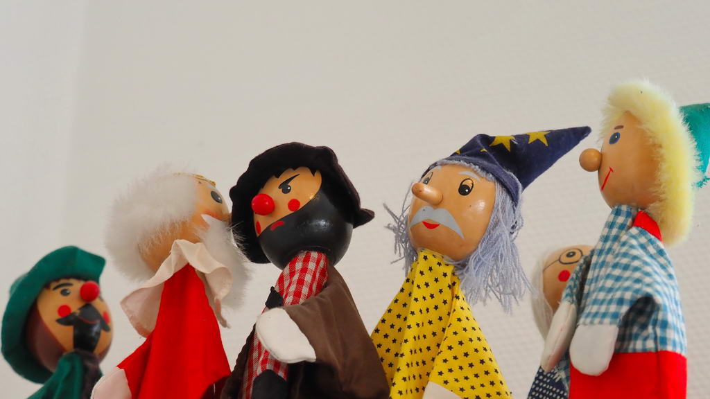 Fünf Puppenkasper stehen in einer Reihe.